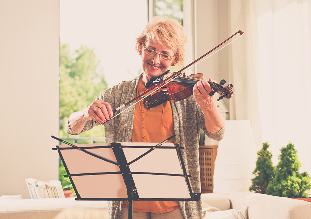 Senior woman playing violin at home