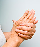 Person massaging hand experiencing arthritis pain