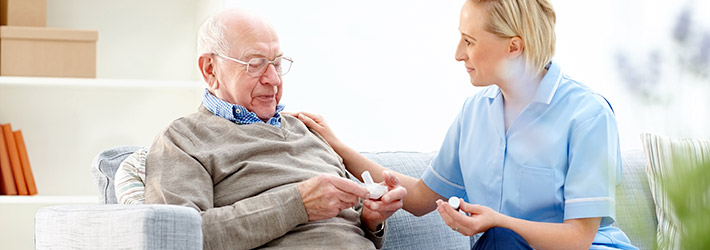Senior man talking with caregiver about medication