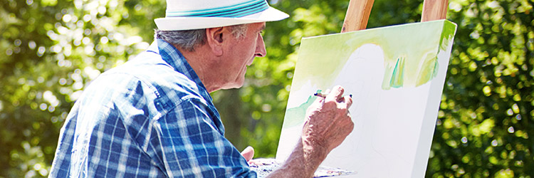 Photo of senior man painting in the outdoors