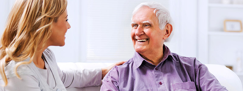 Smiling senior man talking with caregiver